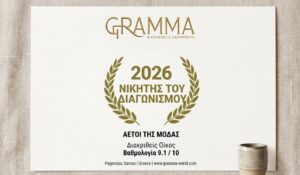 The official award certificate for GRAMMA by Evangelia Grammatiki, recognizing the Cultural House as a 2026 Contest Winner at the "Eagles of Fashion" awards with an outstanding score of 9.1/10. The elegant card is displayed on a natural linen texture, reflecting the brand's authentic aesthetics.
